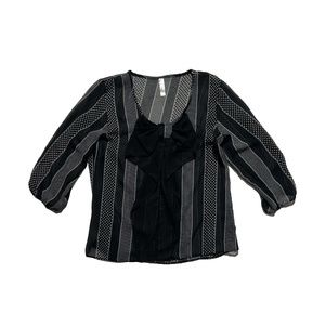 Black dress shirt with white patterns and polka dots, and a bow.